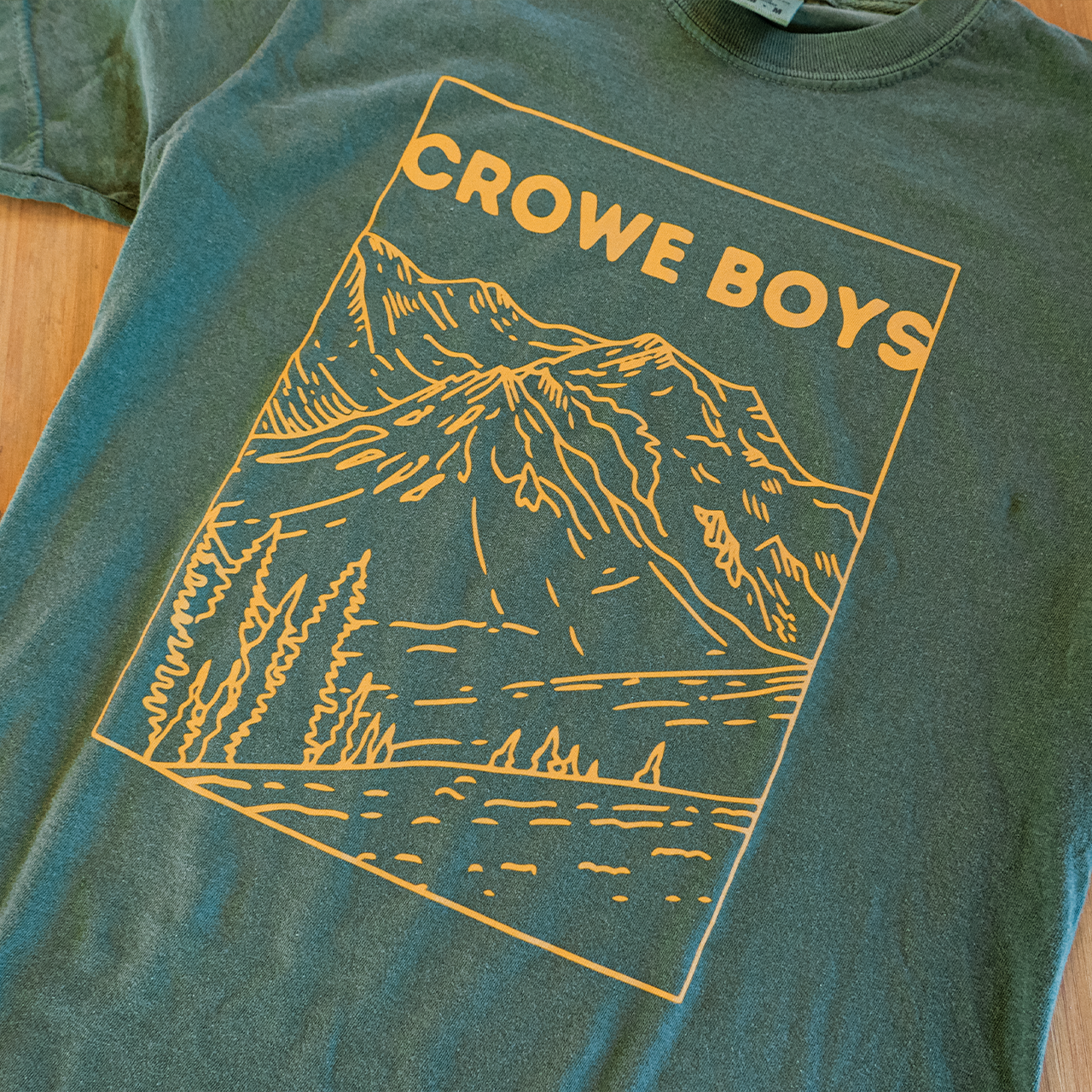 crowe boys green short sleeve tee featuring a yellow mountain design on floor